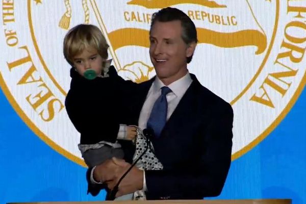 新しいカリフォルニア州知事が、突然現れた息子を抱き上げ就任演説