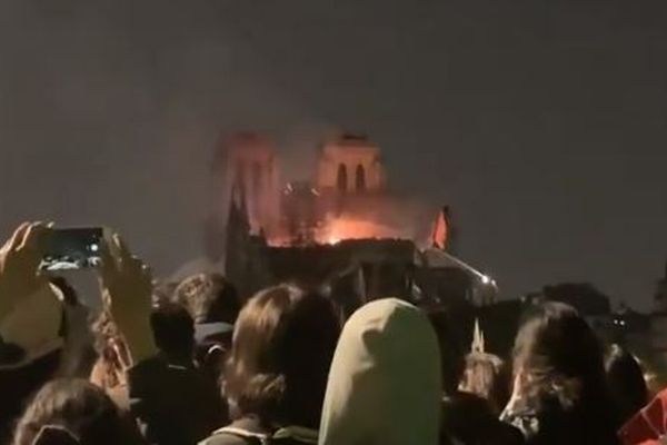 ノートルダム大聖堂の大火災、見守る群衆の間から美しい聖歌が響き渡る
