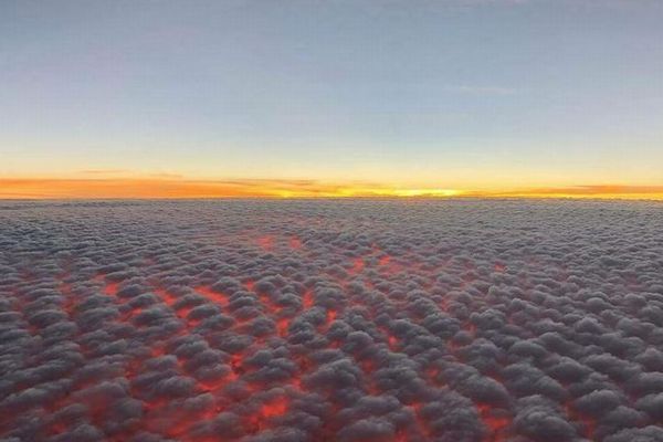 雲の下が燃えるような赤い光に染まる！ハワイ上空で撮影された景色が美しい