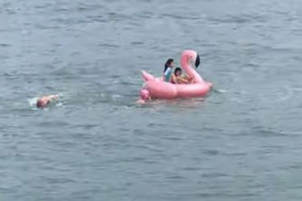 少女たちの乗り物が沖へ流され、大人たちが海へ飛び込み協力して救助