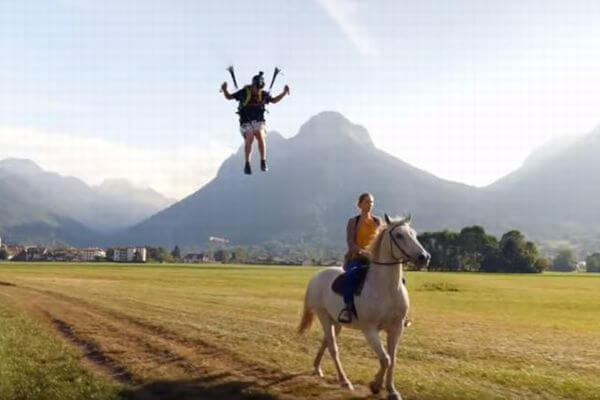 パラグライダーの男性、走っている馬に飛び移る驚きの技を披露