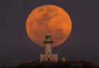 豪の岬に浮上した満月、赤く染まった「ハーベストムーン」の美しい映像