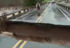 洪水のニュース放映中、レポーターの立つ橋が崩れた