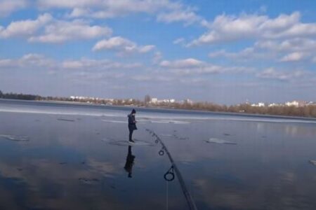 氷の上で流されていく少年、釣り人が竿を使い、リールを巻いて救助