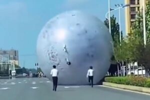 中国で巨大な月の風船が転がり、スタッフが懸命に追いかけていく