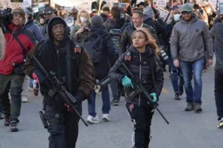 ケノーシャの裁判に抗議する参加者を守るため、武装した父娘が警備