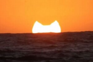 水平線に沈む部分日食の夕陽、ニャンコの耳みたい！【動画】