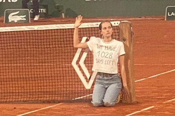 テニスの全仏オープンで、女性がネットに自らを結び付け抗議