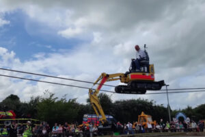 イギリスのテーマパークでショベルカーの綱渡り