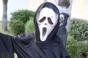 映画『スクリーム』のマスクをかぶった人物が路上に出現、人々を怖がらせる