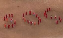 拘留された移民が並んで「SOS」の文字を形作り、助けを求める