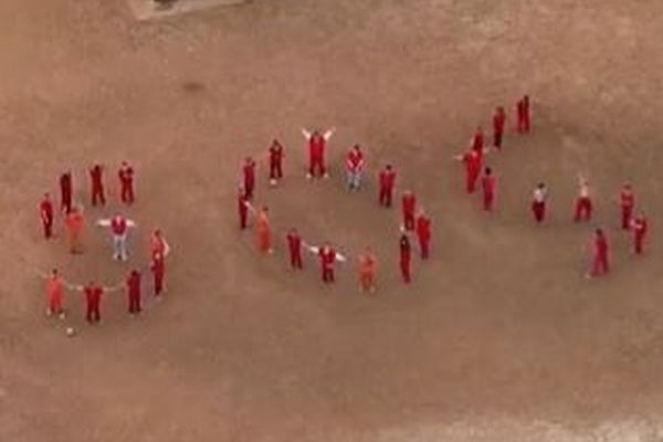 拘留された移民が並んで「SOS」の文字を形作り、助けを求める