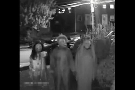 玄関の前にハロウィーンの衣装を着た3人組、住民を脅迫する