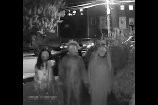 玄関の前にハロウィーンの衣装を着た3人組、住民を脅迫する