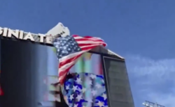 スタジアムのスコアボードにパラシュートが引っかかり、男性が宙吊りに