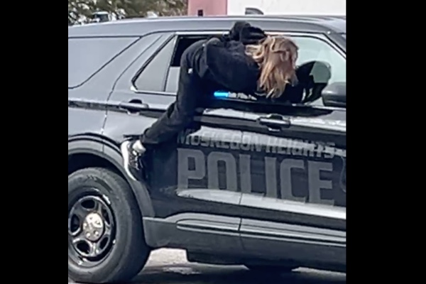 手錠をかけられた女性がパトカーの窓から脱走する様子が撮影される