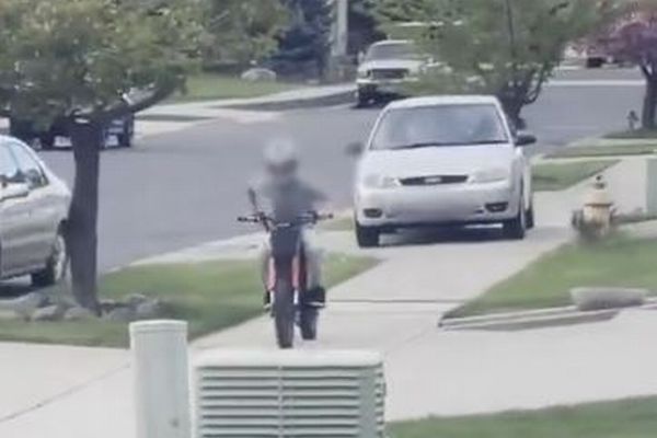 車が歩道に乗り上げ、バイクに乗った少年を轢こうとする【動画】