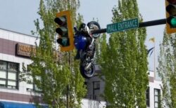 どうしてこうなった？バイクが事故を起こし、信号機にぶら下がる